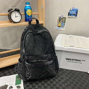Vintage dark gray washed denim backpack with multiple pockets and a minimalist design