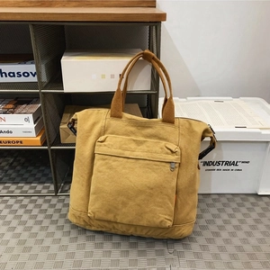 Minimalist ginger yellow canvas backpack with top handles and front zipper pocket