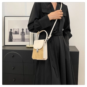 Detail view of mini PU leather handbag with beige and brown contrast and silver buckle