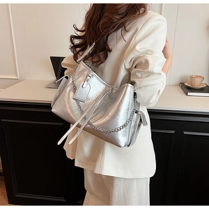 Silver textured PU leather shoulder bag with metallic chain worn by model in office setting