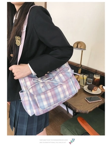 Détail du sac bandoulière à carreaux avec nœuds décoratifs et sangle en nylon ajustable