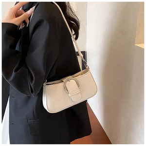 Detail of minimalist beige PU leather underarm bag with a large silver metal ring buckle