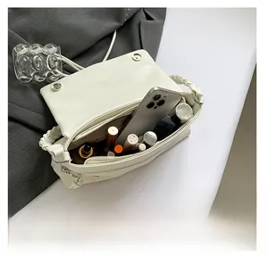 Detail shot of the interior of a white PU leather shoulder bag showing storage space
