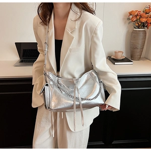 Close-up of metallic silver PU handbag with chain detail and fringe tassel decoration