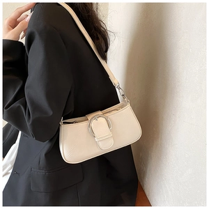 Chic cream white PU leather shoulder bag with a silver round buckle worn over a black blazer