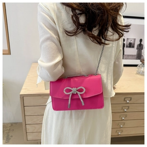 Hot pink PU leather crossbody bag with rhinestone bow detail and metal chain strap