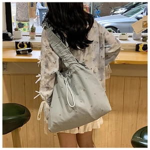 Detail of light blue pleated tote bag with rhinestones and wide shoulder strap