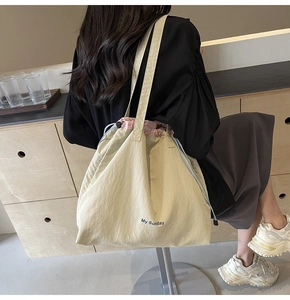 Detail view of large cream nylon tote bag with pink drawstring and My Sunday text