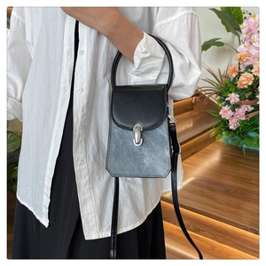 Detail view of stylish color-block crossbody bag with metallic lock and top handle