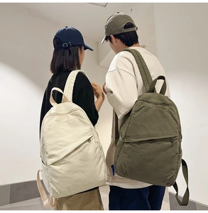 Rear view of minimalist canvas backpacks in beige and olive green on a male and female model