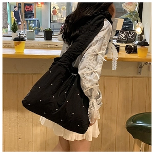 Detail of black nylon tote bag featuring sparkling rhinestone studs and large capacity