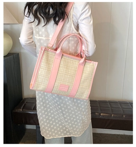 Detail of summer straw woven crossbody bag with pink leather trim shown on model