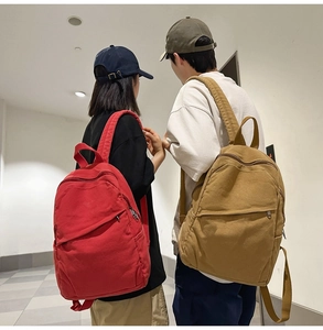 Detailed view of casual canvas backpacks in vibrant red and classic khaki colors
