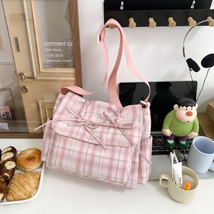 Sac bandoulière en nylon à carreaux roses avec double nœud dans un décor chaleureux