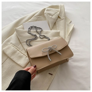 Elegant beige PU leather crossbody bag with silver rhinestone bow and chain strap