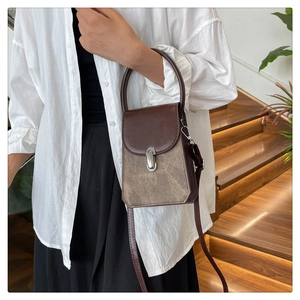 Close-up of retro color-block PU leather handbag with metal buckle on a staircase