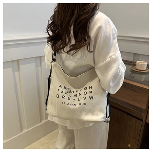 Close-up of cream canvas tote bag with black alphabet printing and durable texture