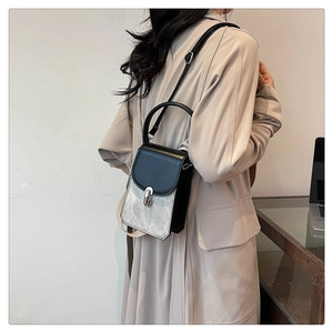 Close-up of contrast color PU leather crossbody bag with silver metallic clasp