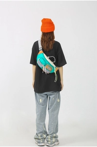 Détail du sac bandoulière en nylon coloré avec plusieurs poches et un style urbain tendance