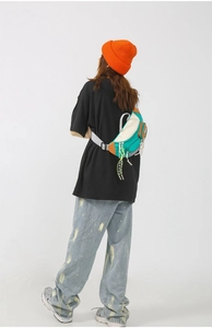 Détail d'un sac bandoulière en nylon tendance avec empiècements multicolores et fermetures