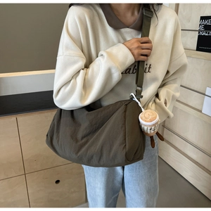 Dark brown fabric crossbody bag with wide strap and cute coffee cup plush charm