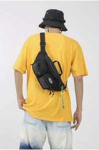 Détail du sac bandoulière en nylon noir avec poches en mesh et cordon vert fluo
