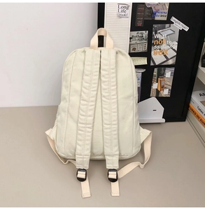 Detailed back view of cream canvas backpack with wide adjustable shoulder straps