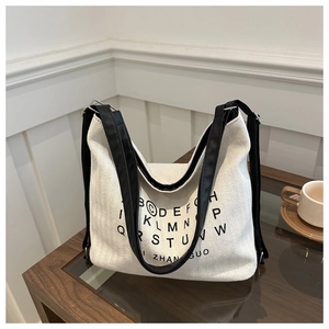 Minimalist beige herringbone canvas tote bag with black straps and typography design