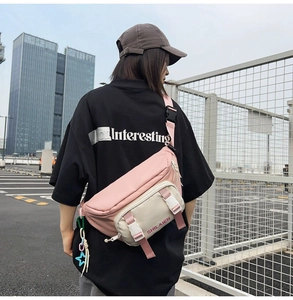 Detail of trendy nylon waist bag with pink and beige color block and star pendant charm