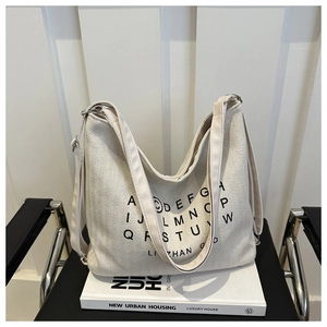 Minimalist beige canvas tote bag with black alphabet print and adjustable strap