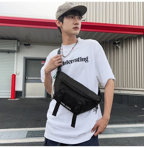 Detail view of the black nylon crossbody bag featuring double buckles and logo print