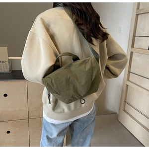 Olive green nylon crossbody bag with pleated texture and adjustable shoulder strap