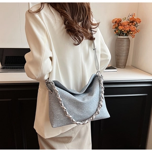 Detail of light blue textured PU leather crossbody bag featuring a chunky silver chain strap