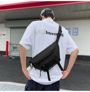 Detail view of the black nylon fanny pack with stylish buckle and brand logo text