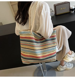 Detail of multi-color striped woven tote bag with thick beige rope handles for summer leisure