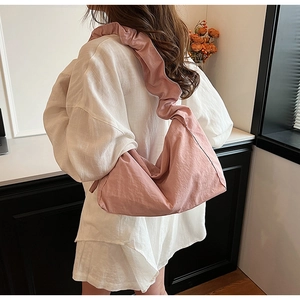 Detailed view of pink nylon hobo bag featuring a distinctive ruffled cloud shoulder strap