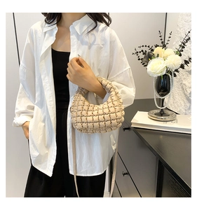 Detail view of beige quilted bubble tote bag with cloud texture and shoulder strap