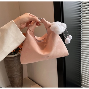 Detailed macro view of pink suede crossbody bag featuring a cute white plush cloud charm