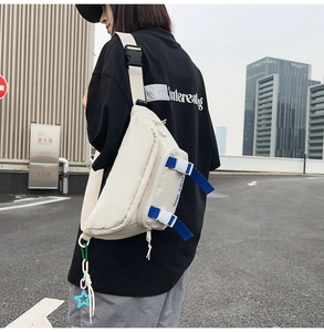 Close-up of nylon belt bag with blue adjustable strap and star pendant detail