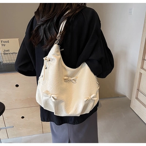 Detail of off-white Hobo bag with pleated texture and decorative 3D bows for women