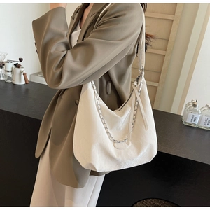 Detailed view of white PU leather hobo bag with silver chain strap and pleated texture