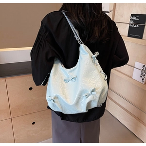 Detail view of mint green wrinkled leather tote with elegant bow knot decorations