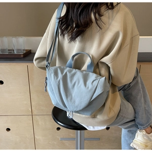 Detail showing the adjustable strap and light blue canvas fabric of the shoulder bag