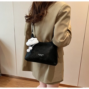 Close-up of black PU shoulder bag featuring white lettering and a plush cloud keychain