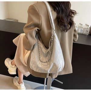 Detail of silver metallic hobo bag featuring pleated PU texture and silver chain strap