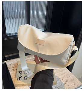 Detail einer beigen Umhängetasche aus mattem Nylon mit verstellbarem Schultergurt und Klappe