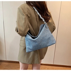 Detailed view of blue glitter PU hobo bag with a silver chain strap worn by a model