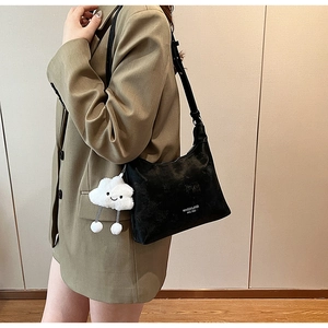Detail of black PU shoulder bag with soft textured finish and cute white cloud pendant