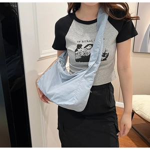 Detail of light blue nylon crossbody bag showing the draped slouchy design on a model