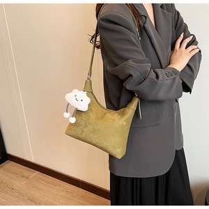 Detail view of mustard green PU leather crescent shoulder bag with white plush cloud charm